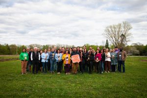 group photo of faculty and staff on Bay Tour. Will Lipske holding "Hello Wisconsin" sign.