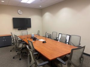 Conference room with a long table in the middle surrounded by chairs