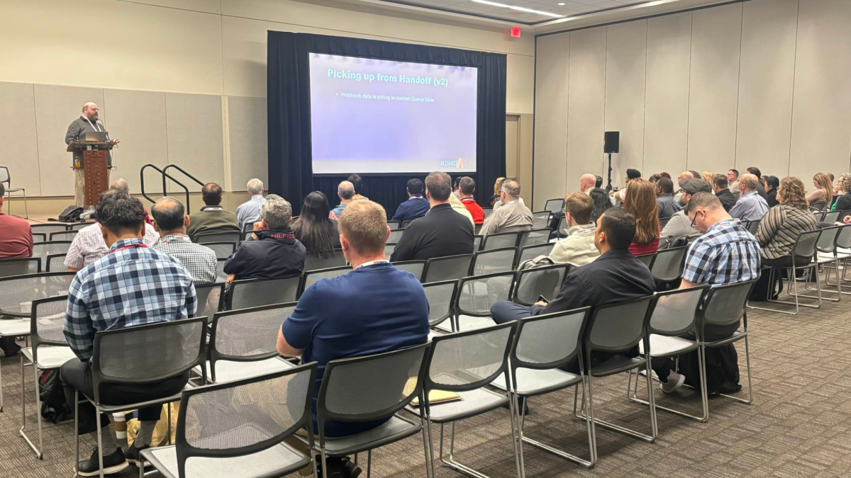 An audience watches a presentation in an exhibition hall.
