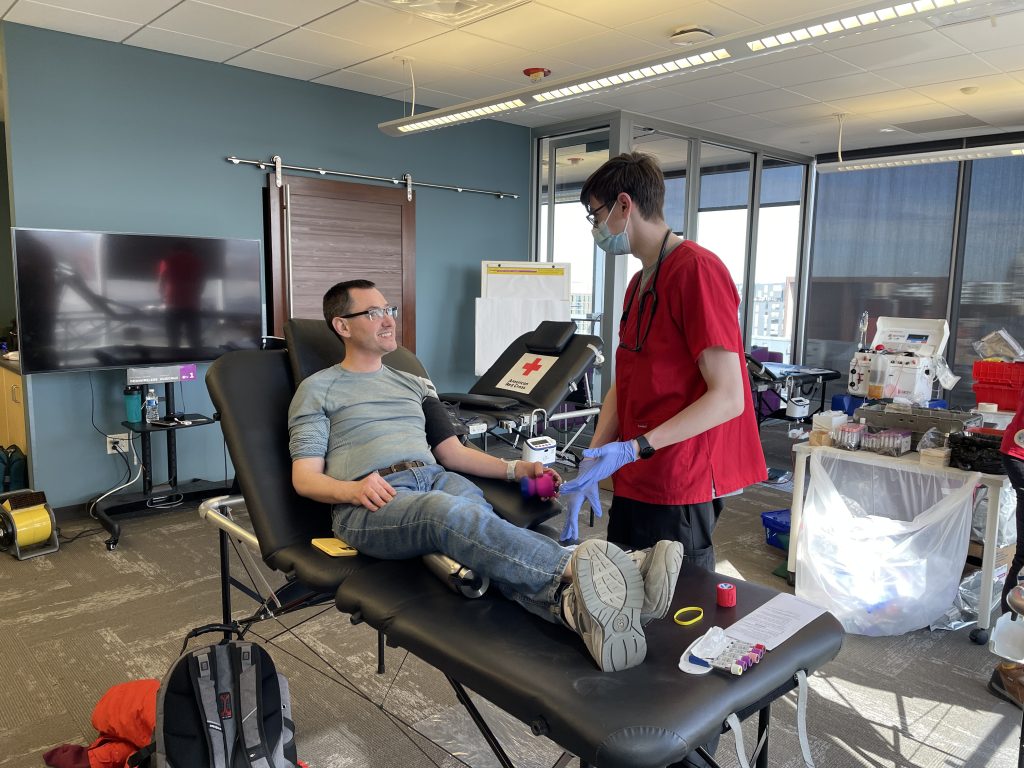A man sits on a blood donation bed.
