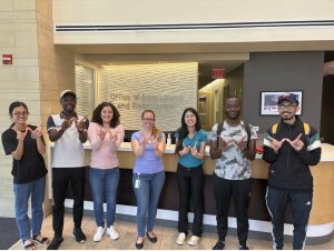 the 8th class of King Morgridge Scholars pose with W hands in the Office of Admissions and Recruitment