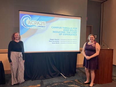 Two women stand in front of a presentation screen.