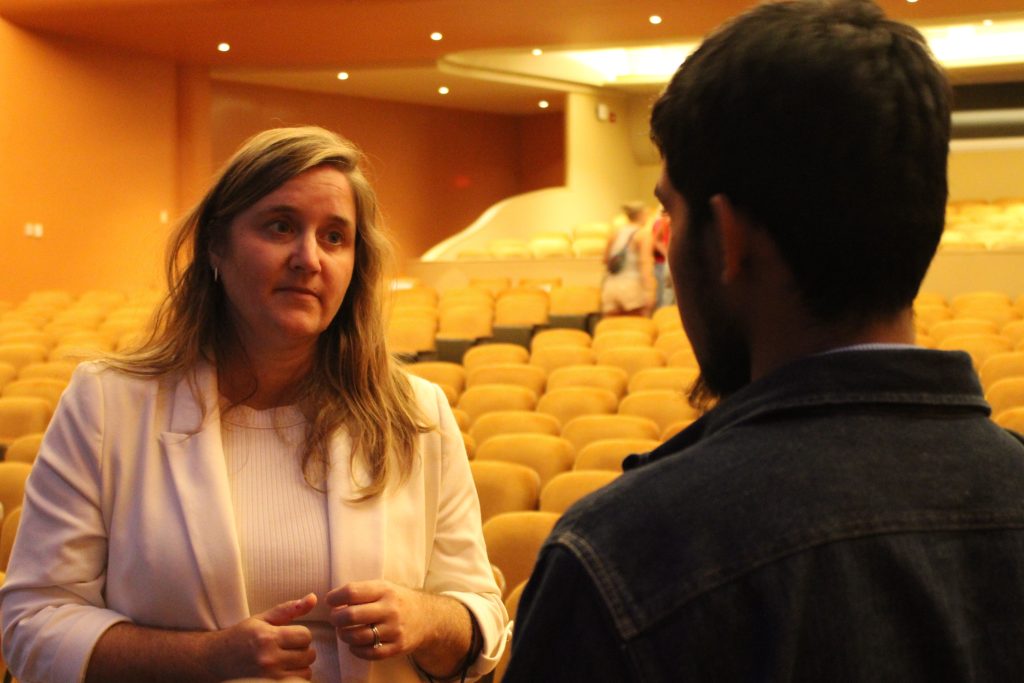 Two people talking in an empty auditorium.