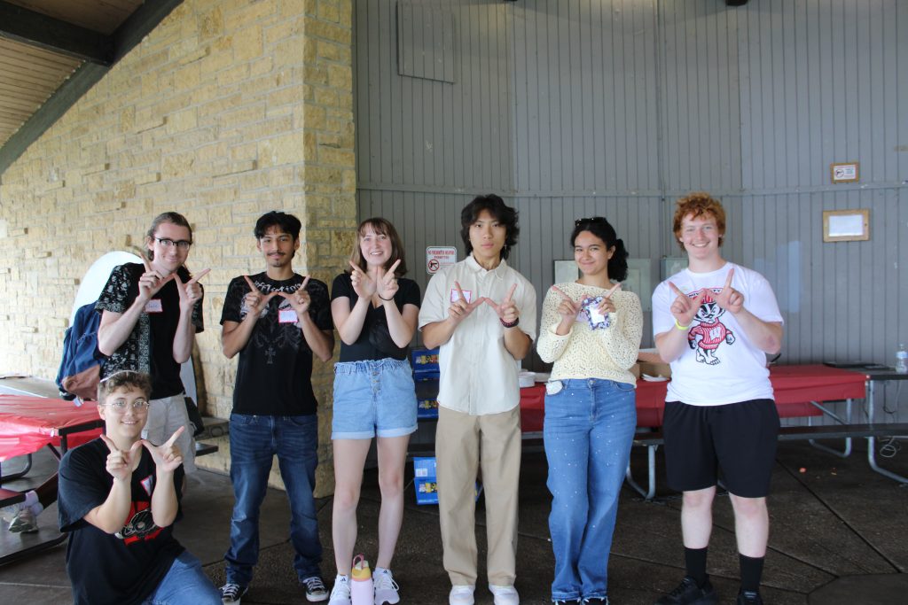 A group of students throwing the W sign with their hands.