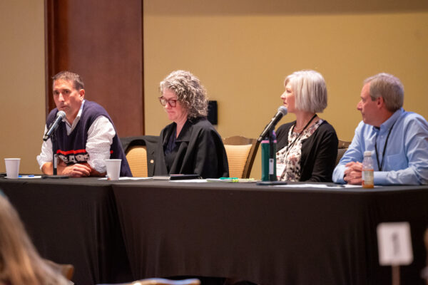 Four people at a table with microphones in front of them