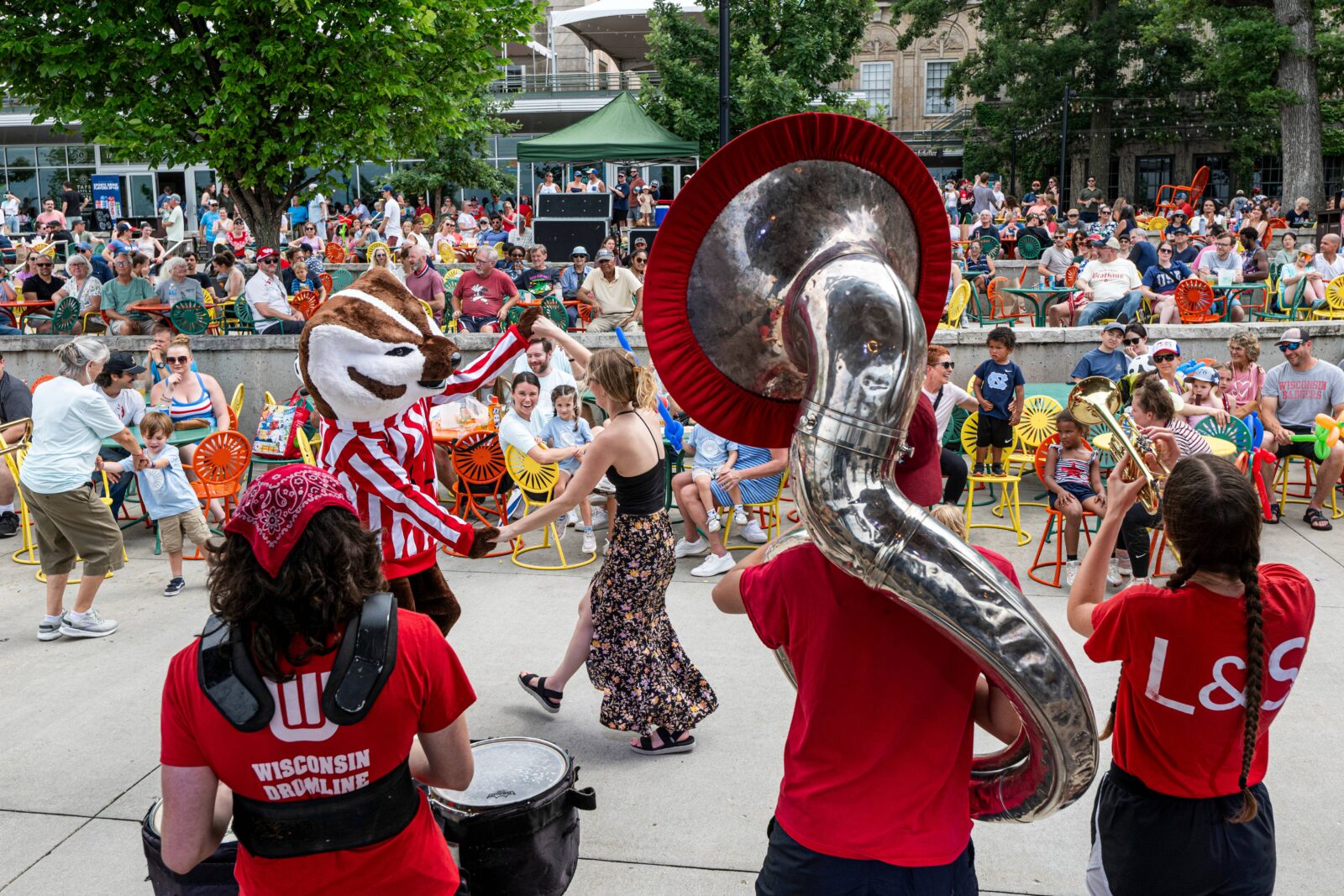 Bucky dances with a woman in a dress while the UW band plays at the Memorial Union.